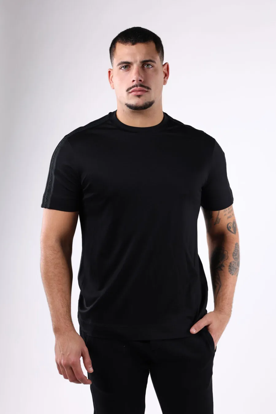 Camiseta negra con logo en franja en mangas