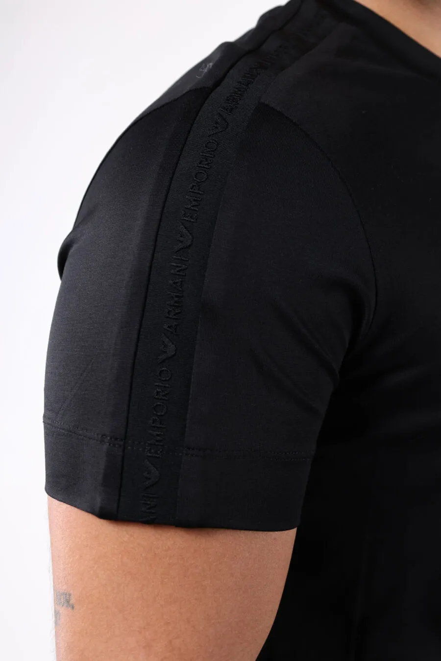 Camiseta negra con logo en franja en mangas