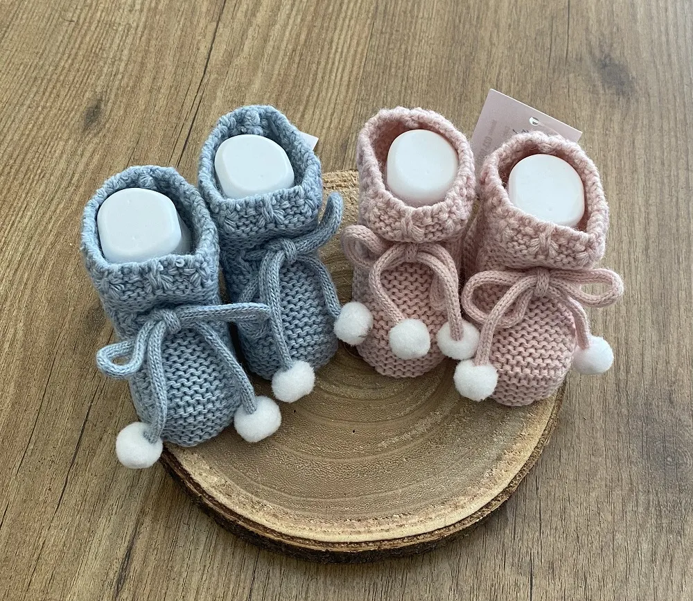 Chubby knit booties. With raw pompoms.